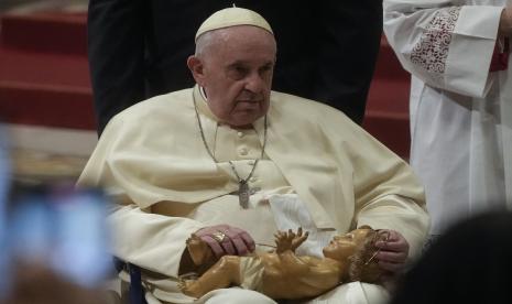 Paus Fransiskus memegang patung Bayi Yesus saat memimpin Misa Malam Natal, di Basilika Santo Petrus di Vatikan, Sabtu, 24 Desember 2022. 