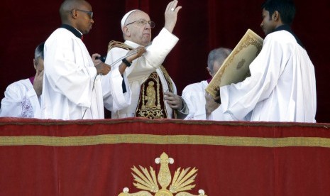 Paus Fransiskus menyampaikan pesan Natal Urbi et Orbi (Untuk Kota dan Dunia) dari balkon utama St. Peter's Basilica di Vatikan, Senin (25/12).