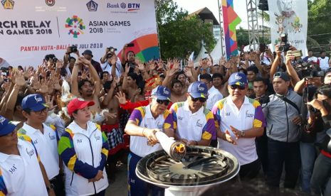 Pawai api obor (torch relay) Asian Games 2018 di Pantai Kuta, Bali, Senin (23/7). Bali menjadi kota ke-20 dari 64 kota di 18 provinsi Indonesia yang disinggahi tim pembawa api obor Asian Games 2018. 