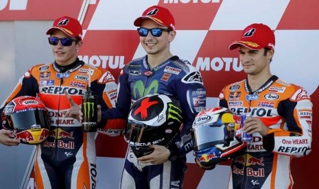 Pebalap Honda asal Spanyol, Marc Marquez (kiri), dan Dani Pedrosa berpose bersama kompatriot pebalap Yamaha, Jorger Lorenzo (tengah), usai balapan seri GP Valencia di Sirkuit Ricardo Tormo, Valencia, Spanyol, Ahad (8/11). 