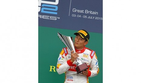 Pembalap Indonesia Rio Haryanto membawa piala usai memenangi balapan GP2 Series di Sirkuit Silverstone, Inggris, Ahad (5/7).