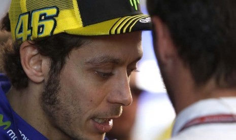 Pebalap Italia, Valentino Rossi, berbicara dengan anggota tim usai balapan seri GP Valencia di Sirkuit Ricardo Tormo, Valencia, Spanyol, Ahad (8/11). 