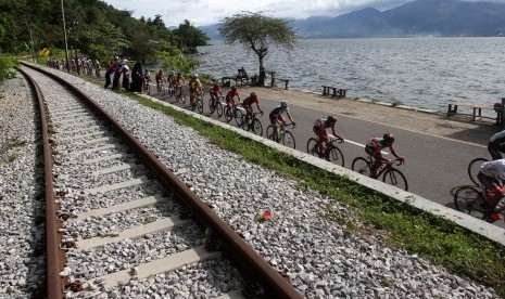 Pembalap memacu sepedanya pada etape ke enam Tour De Singkarak, saat melintas di tepi danau Singkarak, Kota Solok, Sumatera Barat, Jumat (9/11/2018). 