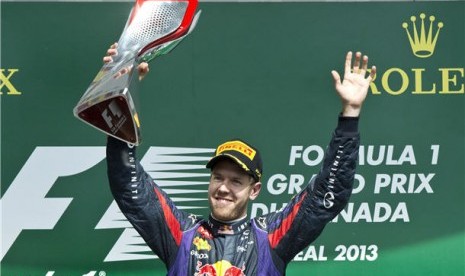 Pebalap Red Bull, Sebastian Vettel, memegang trofi usai memenangkan balapan Formula Satu seri GP Kanada pada Ahad (9/6).