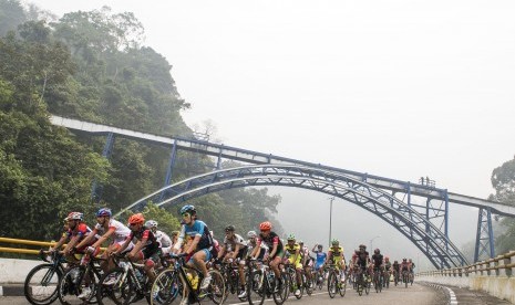 Pebalap sepeda beradu kecepatan saat melintasi kawasan wisata Lembah Anai pada Tour De Singkarak Etape Keenam di Tanah Datar, Sumatera Barat, Kamis (8/10). 