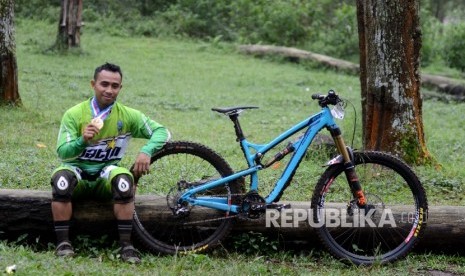 Pebalap sepeda gunung Jawa Barat Popo Ario Sejati menujukkan mendalinya usai final Downhill Individual Men Elite PON XIX di Cikole, Lembang, Jawa Barat, Rabu (20/9). 