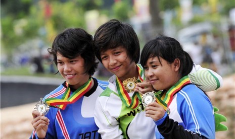 Pebalap sepeda Jawa Tengah, Suswanti (kiri) dan Rina Purnamasari (kanan), memperlihatkan medali pada final balap sepeda BMX PON XVIII di arena BMX, Siak, Riau. 