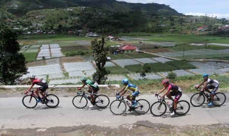 Pebalap sepeda melintas di area perkebunan warga saat mengikuti Tour de Singkarak 2018 pada etape ke tujuh, di Kabupaten Solok, Sumatera Barat, Sabtu (10/11/2018).