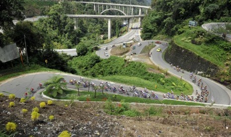  Pebalap sepeda melintasi jalur Fly Over Kelok Sembilan pada etape III Tour de Singkarak 2014 dengan rute Limapuluhkota - Tanah Datar di Limapuluh Kota, Sumbar, Senin (9/6). (Antara/Wahyu Putro)