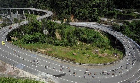  Pebalap sepeda melintasi jalur Fly Over Kelok Sembilan pada etape III Tour de Singkarak 2014 dengan rute Limapuluhkota - Tanah Datar di Limapuluh Kota, Sumbar, Senin (9/6). (Antara/Wahyu Putro)