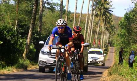 Pebalap sepeda Sapura Cycling Team Ewart Jesse (kiri) beradu cepat dengan pebalap sepeda KFC Cycling Team Selamat Juangga di tanjakan pada kejuaraan International Tour de Banyuwangi Ijen (ITDBI) di Banyuwangi, Jawa Timur, Sabtu (29/9).