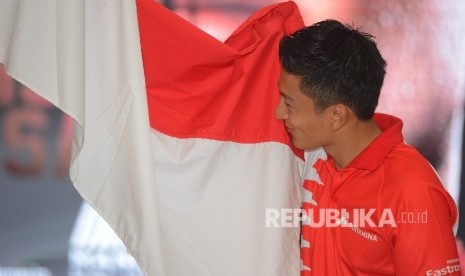 Pebalap Tim Manor Racing Formula 1 Rio Haryanto mencium bendera Indonesia yang telah diberikan oleh Menteri Pemuda dan Olahraga Imam Nahrawi saat menggelar konferensi pers di Jakarta, Kamis (18/2).