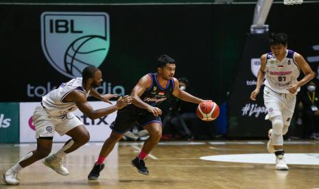 Pebasket Amartha Hangtuah Jakarta Stevan Wilfredo Neno (tengah) berusaha melewati pebasket Rans PIK Basketball Club Akeem W Scoot (kiri) dan Agus Salim (kanan) pada pertandingan lanjutan Indonesian Basketball League (IBL) 2022 di Hall Basket Kompleks Gelora Bung Karno (GBK), Senayan, Jakarta, Senin (14/3/2022). Rans PIK Basketball Club mengalahkan Amartha Hangtuah Jakarta dengan skor 66-64.