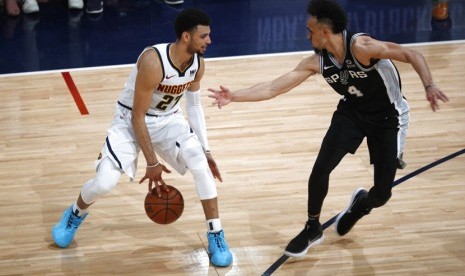 Pebasket Denver Nuggets Jamal Murray (kiri) mencoba melewati pebasket San Antonio Spurs Derrick White (kanan) di paruh kedua dari seri playoff bola basket NBA.