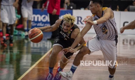 Pebasket Garuda Bandung, Rionny Rahangmetan (kiri) berusaha melewati hadangan pebasket Satya Wacana Salatiga, Andreas Rismawan (kanan) pada Turnamen Pramusim Indonesian Basketball League (IBL) di Gor Sritex Arena, Solo, Jawa Tengah, Kamis (18/10/2018). 