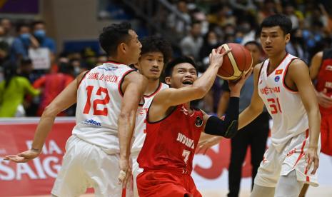 Pebasket Indonesia Andakara Prastawa (kanan) mendapatkan kawalan pebasket Vietnam Justin Young Duong (kanan) dalam laga lanjutan cabang basket SEA Games 2021, di Thanh Tri District Sporting Hall, Hanoi, Vietnam, Sabtu (21/5/2022). A