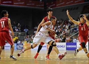 Pebasket Indonesia Andi Poedjakesuma (tengah) mencoba menerobos pebasket Singapura Wei Jie Oh (kanan) pada pertandingan bola basket SEA Games XXVI, di Arena Sportmall Kelapa Gading, Jakarta, Rabu (16/11) malam. 