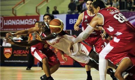 Pebasket Indonesia Warriors, Christopher Daniels (tengah), berebut bola dengan pebasket San Miguel Beerman dalam laga Asean Basketball League (ABL) di lapangan tennis indoor Senayan, Jakarta, Jumat (8/3) malam. 