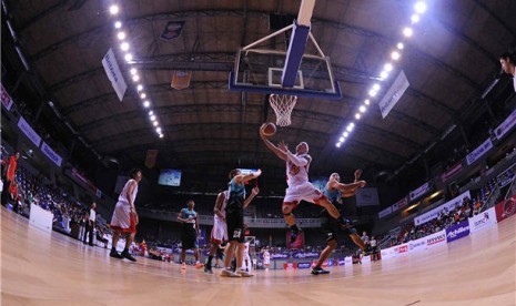 Pebasket Indonesia Warriors, Mario Wuysang (tengah) melakukan lay-up dengan dikawal pebasket Westports Malaysia Dragons saat pertandingan babak reguler ASEAN Basketball League (ABL). 