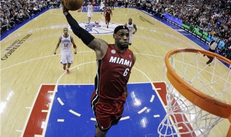 Pebasket Miami Heat, LeBron James, melakukan aksi dunk saat menghadapi Philadelphia 76ers di laga NBA di Philadelphia pada Rabu (13/3). 