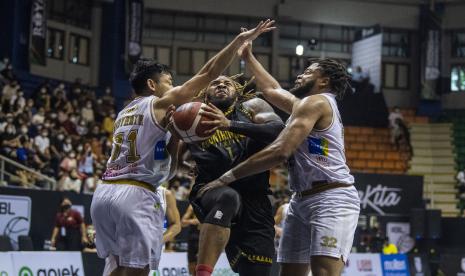 Pebasket NSH Mountain Gold Timika Michael E Glover (tengah) berusaha melakukan lay up shoot dibayangi pebasket West Bandits Combiphar Solo Bilal N Richardson (kanan) dan Widyanta Putra Teja (kiri) saat pertandingan Playoff Liga Bola Basket Indonesia (IBL) Tokopedia 2022 di Gor C-Tra Arena, Bandung, Jawa Barat, Minggu (14/8/2022). NSH Mountain Gold Timika berhasil mengalahkan West Bandits Combiphar Solo dengan skor 70-47. 