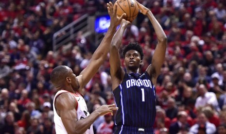 Pebasket Orlando Magic Jonathan Isaac (kanan) di hadang Pebasket Toronto Raptors Serge Ibaka (kiri) saat berusaha memasukan bola pada paruh kedua seri playoff putaran pertama basket NBA di Toronto.