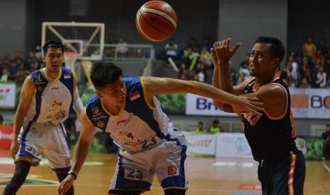 Pebasket Pelita Jaya Amin Prihantono (kanan) berebut bola dengan pebasket Satria Muda Pertamina Avan Seputra (tengah) saat gelaran final Indonesia Basket League di Britama Arena, Jakarta, Ahad (7/5) malam. 