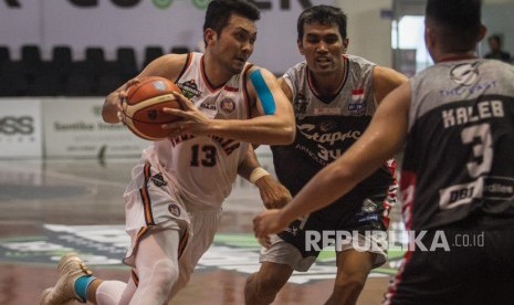 Pebasket Pelita Jaya Basketball Ponsianus Nyoman Indrawan (kiri) berusaha melewati hadangan pebasket Stapac Jakarta Muhammad Thoyip (kedua kanan) dan Kaleb Ramot Gemilang (kanan) pada Turnamen Pramusim Indonesian Basketball League (IBL) di Gor Sritex Arena, Solo, Jawa Tengah, Selasa (16/10/2018).