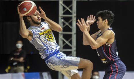 Pebasket Prawira Bandung M Reza Fahdani Guntara (kiri) mencoba melewati pebasket Indonesia Patriots Aldy Izzatur Rachman dalam pertandingan lanjutan Indonesia Basket League (IBL) 2022.