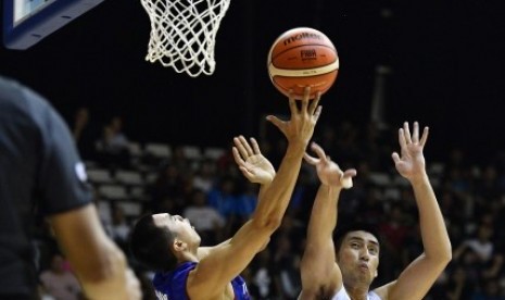 Pebasket putra Thailand Bhurinun Nantho (kiri) mencoba memasukkan bola dengan dikawal pebaket Indonesia Christian Ronaldo Sitepu saat pertandingan babak kualifikasi bola basket 18th Asian Games Invitation Tournament di Hall Basket Senayan, Jakarta, Ahad (11/2). 