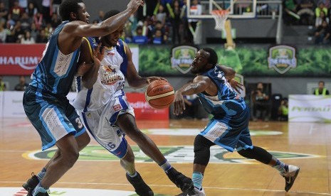 Pebasket Satria Muda Pertamina Jakarta Carlos Smith (tengah) diadang dua pebasket Pelita Jaya Kore White (kiri) dan Martavious Irving (kanan).