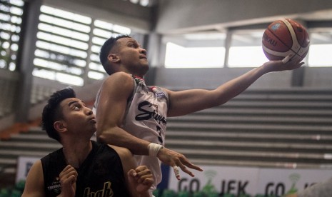 Pebasket Stapac Jakarta, Kaleb Ramot Gemilang (kanan) berusaha mencetak angka dengan dihadang pebasket Hangtuah, Steven Carsera (kiri) pada Turnamen Pramusim Indonesian Basketball League (IBL) di Gor Sritex Arena, Solo, Jawa Tengah, Rabu (17/10/2018). Pada pertandingan tersebut Stapac Jakarta menang dengan skor 68-59.