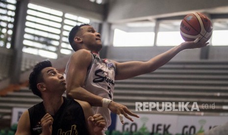 Pebasket Stapac Jakarta, Kaleb Ramot Gemilang (kanan) berusaha mencetak angka dengan dihadang pebasket Hangtuah, Steven Carsera (kiri) pada Turnamen Pramusim Indonesian Basketball League (IBL) di Gor Sritex Arena, Solo, Jawa Tengah, Rabu (17/10/2018). 