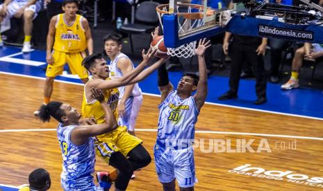 Pebasket Tangerang Hawks Basketball Club Keefe Fitrano Yoshe (kedua kiri) melakukan lay up dibayangi pebasket Prawira Bandung Moh Alan As