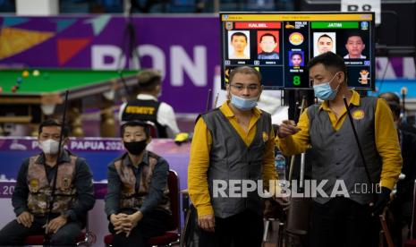 Pebiliar Jawa Timur Rudy Susanto (kanan) berdiskusi dengan rekannya Erwin Kurniawan (kedua kanan) sebelum menyodok bola dalam pertandingan final biliar nomor bola 9 ganda putra PON Papua di GOR Biliar SP 5, Kabupaten Mimika, Papua, Senin (11/10/2021). Rudy bersama rekannya, Erwin Kurniawan mengalahkan pebiliar Kalimantan Selatan Arun dan Noor Hidayatullah dengan skor 8-4 sekaligus meraih medali emas nomor tersebut. 