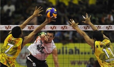 Pebola voli Jakarta BNI 46, Curt Toppel (tengah), melakukan smash ke arah pebola voli Semarang Bank Jateng pada final Proliga 2012. 