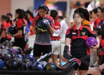 Peboling putri Indonesia Sharon Liman Santoso (kanan) bersiap melempar bola dalam nomor tunggal putri bowling SEA Games XXVI di Jaya Ancol Bowling Center, Jakarta Utara, Selasa (15/11).