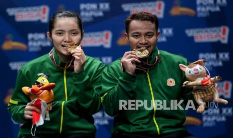 Pebulu tangkis ganda campuran Jawa Timur Rehan Naufal Kusharjanto dan Marheilla Gischa Islami berpose dengan medali emasnya usai memenangkan pertandingan final Bulu Tangkis Ganda Campuran PON Papua di GOR Waringin Kotaraja, Kota Jayapura, Papua, Rabu (13/10/2021). Rehan Naufal Kusharjanto dan Marheilla Gischa Islami menang atas lawannya pebulu tangkis ganda campuran Jawa Tengah Bagas Maulana dan Indah Cahya Sari Jamil dengan skor 21-19, 19-21, 15-6. 