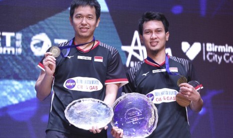 Pebulu tangkis ganda putra Indonesia Hendra Setiawan (kiri) dan Mohammad Ahsan menunjukan medali usai memenangi pertandingan melawan ganda putra Malaysia Aaron Chia dan Soh Wooi Yik pada babak final All England 2019 di Arena Brimingham, Inggris, Minggu (8/3/2019).