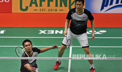 Pebulu tangkis ganda putra Indonesia Mohammad Ahsan (kiri) disaksikan rekannya Hendra Setiawan mengembalikan kok.