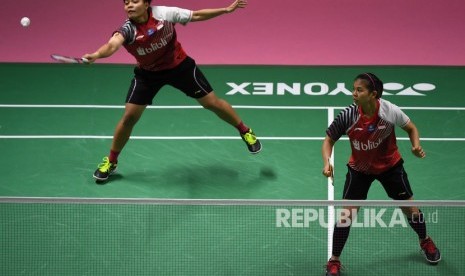 Pebulu tangkis ganda putri Indonesia Apriyani Rahayu (kiri) mengembalikan kok disaksikan rekannya dan Greysia Polii (kanan) saat pertandingan babak penyisihan grup Piala Uber 2018 melawan pasangan Malaysia Yea Ching Goh dan Lee Meng Yean di Impact Arena, Bangkok, Thailand, Senin (21/5).