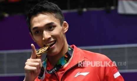 Pebulu tangkis Indonesia Jonatan Christie menggigit medali usai prosesi upacara pemberian medali di final cabang bulu tangkis nomor tunggal putra Asian Games 2018 di Istora Senayan, Jakarta, Selasa (28/8). 