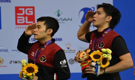 Pebulu tangkis Indonesia Leo Rolly Carnando dan Daniel Marthin (kanan) memberi hormat ke bendera merah putih saat upacara penghormatan pemenang final bulu tangkis ganda putra SEA Games 2021 Vietnam di Bac Giang Gymnasium, Vietnam, Ahad (22/5/2022). Leo Rolly Carnando dan Daniel Marthin meraih medali emas setelah mengalahkan pasangan rekan senegaranya Yeremia Erich Yoche Yacob Rambitan dan Pramudya Kusumawardana dalam dua set langsung, 21-17 dan 21-19.