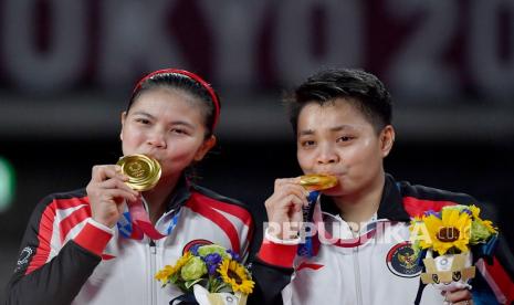 Pebulu tangkis ganda putri Indonesia Greysia Pollii (kiri) dan Apriyani Rahayu mencium medali emas yang berhasil diraih untuk nomor bulu tangkis ganda putri Olimpiade Tokyo 2020 di Musashino Forest Sport Plaza, Tokyo, Jepang, Senin (2/8/2021). Greysia Pollii/Apriyani Rahayu berhasil meraih medali emasi setelah mengalahkan ganda putri Cina, Chen/Jia Yi Fan, dua set langsung. 21-19 dan 21-15.