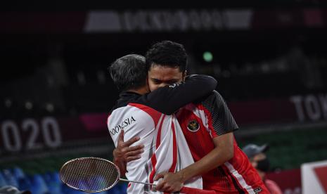 Pebulutangkis tunggal putra Indonesia Anthony Sinisuka Ginting (kanan) memeluk pelatihnya Hendry Saputra seusai mengalahkan tunggal putra Denmark Anders Antonsen dalam perempatfinal Olimpiade Tokyo 2020 di Musashino Forest Sport Plaza, Tokyo, Jepang, Sabtu (31/7/2021). Anthony Sinisuka Ginting berhasil lolos ke semifinal setelah menang 21-18, 15-21, dan 21-18.