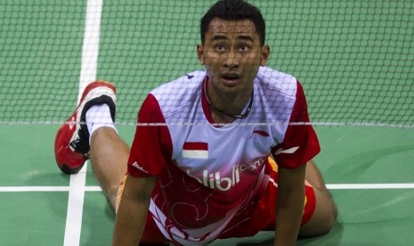 Pebulutangkis tunggal putra Indonesia, Tommy Sugiarto, terjatuh saat berusaha mengembalikan kok ke arah pebulutangkis Singapura, Derek Wong, dalam partai pertama penyisihan Grup A Piala Thomas 2014 di Stadion Bulutangkis, Siri Fort Sport Complex, New Delhi