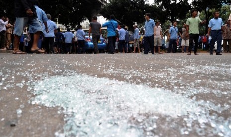 Pecahan kaca mobil berserakan akibat pengerusakan taksi saat demo angkutan umum di Jl Sudirman, Jakarta, Selasa (22/3).