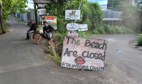 Pecalang atau petugas pengamanan adat Bali berjaga di sekitar kawasan wisata Pantai Balangan yang ditutup sementara di Badung, Bali Ahad (29/3/2020). Pengelola sejumlah destinasi pariwisata di Pulau Dewata masih melakukan penutupan kunjungan wisatawan sementara sebagai salah satu upaya pencegahan penyebaran COVID-19 atau Virus Corona.