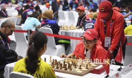 Pecatur Indonesia Simanja Nasip Farta (kedua kanan) menunggu giliran menjalankan bidak saat bertanding melawan pecatur Vietnam Nguyen Thi Kieu pada kategori catur standar P1 perorangan putri Asian Para Games 2018 di Cempaka Putih Sports Hall, Jakarta, Rabu (10/10).