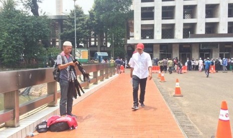 Pedagang atribut bertuliskan kalimat tauhid menawarkan dagangannya di kawasan Masjid Istiqlal, Jumat (26/10)